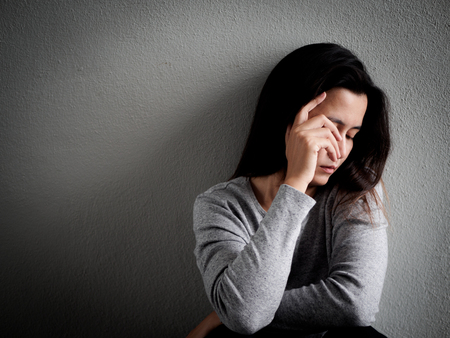Depressed broken hearted woman sitting alone in dark room at home. Lonly , sad, LOVE and  valentines day concept.の写真素材