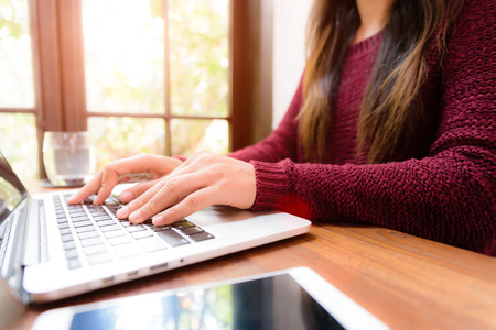 Soft focus Closeup woman hand working on her laptop. Social networking technology concept.の写真素材
