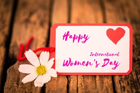 8 March Happy Women's Day message on wooden background with handmade red heart and white and yellow flowers. Womens Day concept.の写真素材