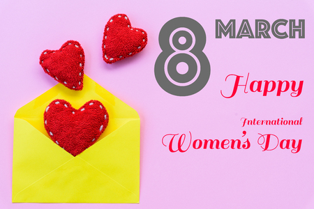 Happy Women's Day message on pink background with handmade red heart inside yellow letter. Womens Day concept.の写真素材