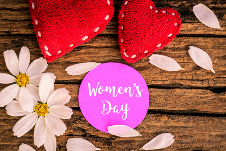 8 March Happy Women's Day message on wooden background with handmade red heart and white and purple...