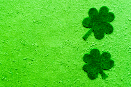 Happy St Patricks Day message on green paper clover and bright green Mulberry paper backgroundの写真素材