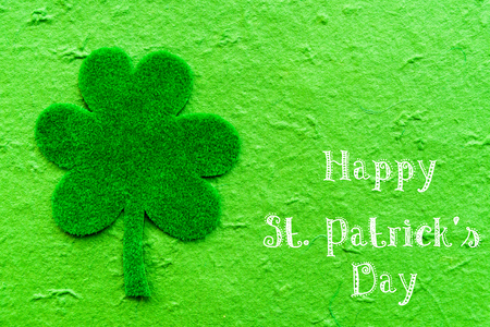 Happy St Patricks Day message on green paper clover and bright green Mulberry paper backgroundの写真素材