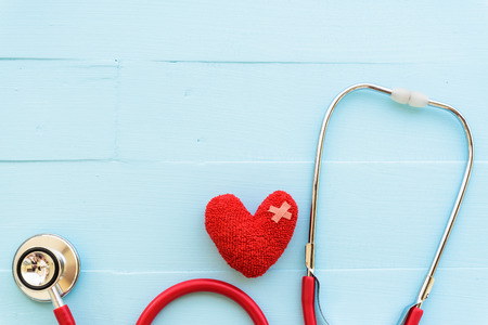 World health day, Healthcare and medical concept. Red heart with Stethoscope, notepad or notebook, thermometer and yellow Pill on Pastel white and blue wooden table background texture.の写真素材