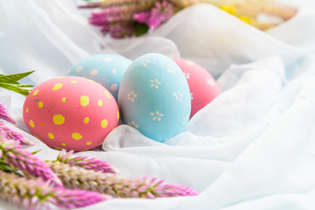 Happy easter! Colorful of Easter eggs in nest with flower,  paper star and Feather on white...