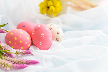Happy easter! Colorful of Easter eggs in nest with flower,  paper star and Feather on white...