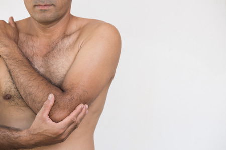 Closeup man elbow and arm pain and injury on white background. Health care and medical concept.の写真素材