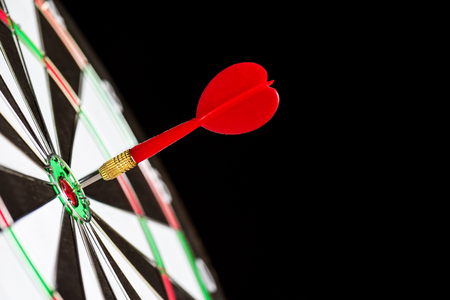 Close up shot red darts arrows in the target center on black background. Business target or goal success and winner concept.の写真素材