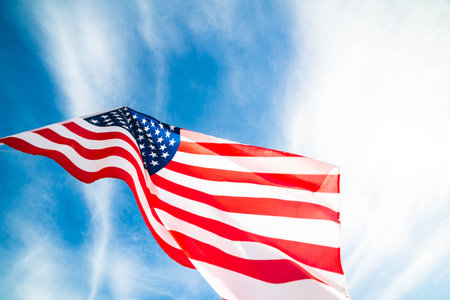 Close up United States of America flag on the blue sky background. USA Independence day, 4 July.