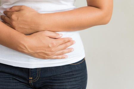 Young woman having painful stomachache. Chronic gastritis. Abdomen bloating concept.の写真素材