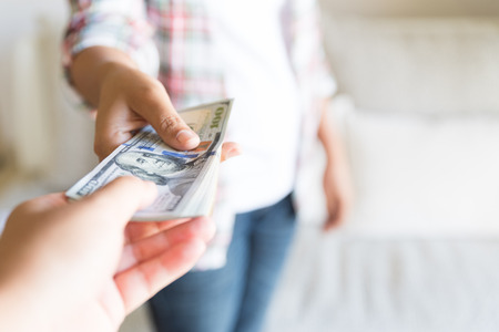 Soft focus on woman hands proposing money us dollar bills to you.の写真素材