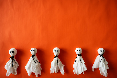 Top view of Halloween crafts, paper ghost on orange paper background with copy space for text. halloween concept.の写真素材