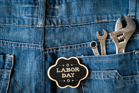 USA Labor day concept, First Monday in September. Different kinds on wrenches, handy tools, America flag and wooden tag on blue jeans background.の写真素材