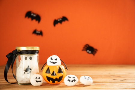 Halloween crafts, ghost and spider on wooden table and orange background with copy space for text. halloween concept.の写真素材