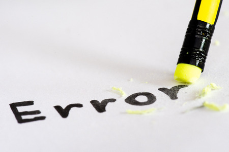 Erase the word Error with a rubber concept of eliminating the error, mistake. closeup of a pencil erasing an "error".の写真素材