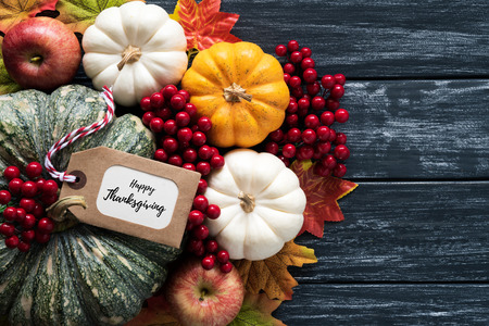 Top view of  Autumn maple leaves with Pumpkin and red berries on old wooden backgound. Thanksgiving...