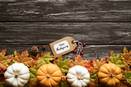 Top view of  Autumn maple leaves with Pumpkin and red berries on old wooden backgound. Thanksgiving day concept.の写真素材
