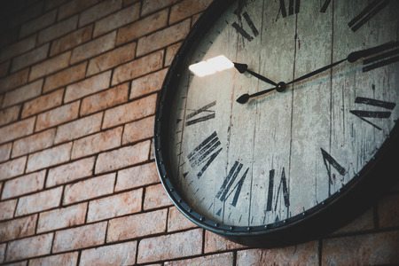 Close up wall clock vintage retro styles hanging on the brick wall.の写真素材