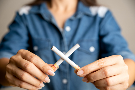 World No Tobacco Day, May 31. STOP Smoking. Close up woman hand holding crossed cigarettes.の写真素材