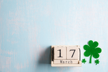 Block calendar for St Patrick's Day, March 17, with green clover leaf, green water and paper tag on white wooden backgroundの写真素材