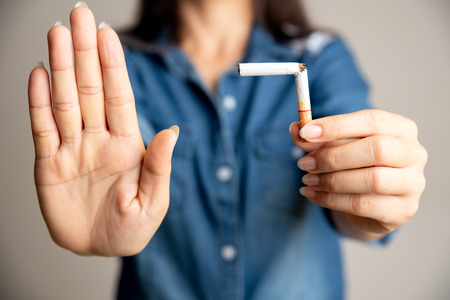 World No Tobacco Day, May 31. STOP Smoking. Close up woman hand breaking, crushing or destroying cigarettes.の写真素材
