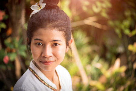 Happy young asian woman holding orchid with a happy smile in graden.の写真素材