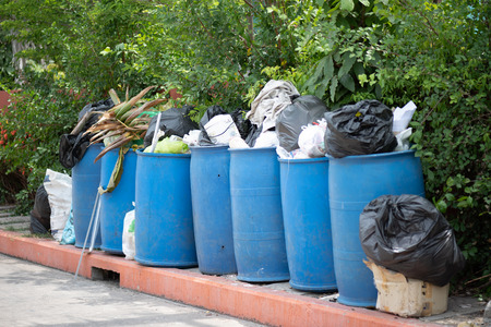 Overflowing garbage bins with household waste in the city.の写真素材