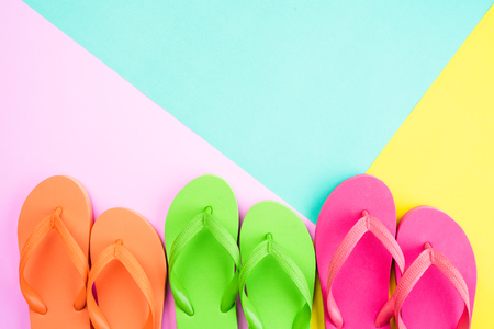 Top view of colorful flip flop on pink and yellow background for summer holiday and vacation concept.の写真素材