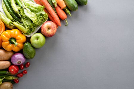 Healthy lifestyle and food concept. Top view of fresh vegetables, fruit, herbs and spices with a empty pink pastel plate on gray background.の写真素材