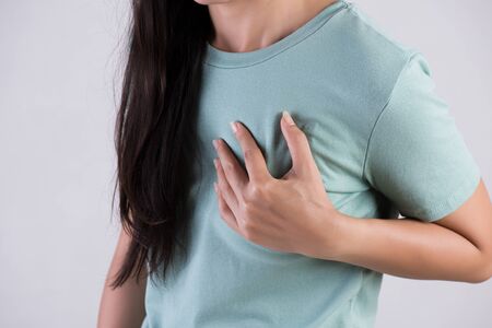 Closeup woman having heart attack. Woman touching breast and having chest pain. Healthcare And...