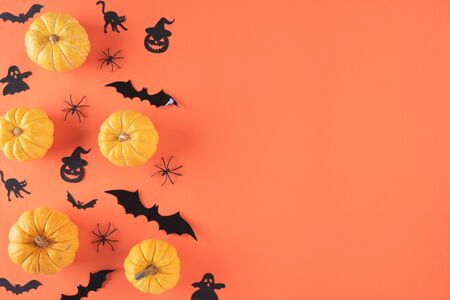 Top view of Halloween crafts, yellow pumpkin, ghost, bat and spider on orange background with copy space for text. halloween concept.の写真素材