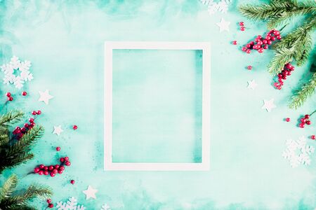Watercolor painting Christmas holidays composition Top view of white picture frame with Christmas tree decoration and red berries on green pastel background with copy space for text.の写真素材