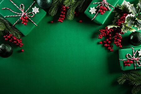 Christmas background concept. Top view of Christmas green gift box with decoration, spruce branches and red berries on green  background.の写真素材
