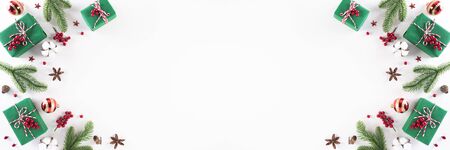 Christmas background concept. Top view of Christmas green gift box with candy cane, snowflakes, red berries and bell on white wooden background.の写真素材