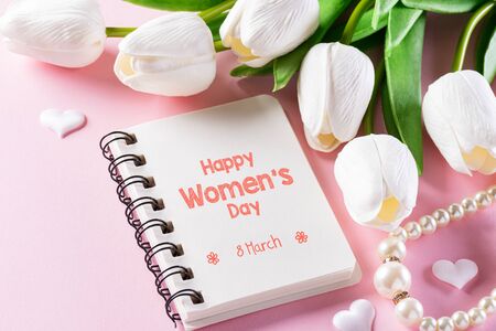 International Women's Day concept. Pink and white tulips with gift box and paper tag text on pink pastel background. Top view flat lay, March 8.の写真素材