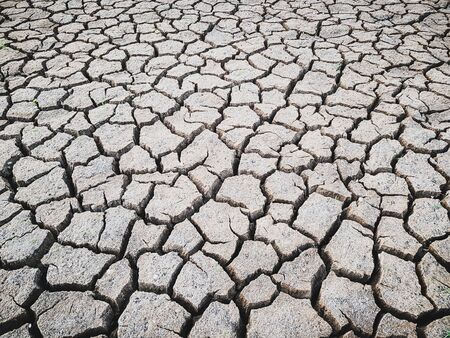 Details of a dried cracked earth soil ground background.