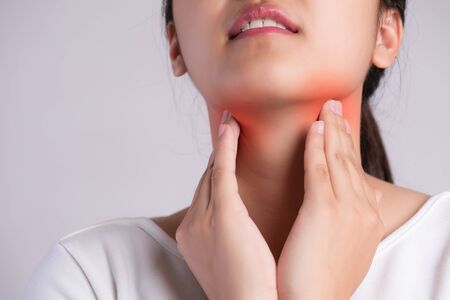 Sore Throat. Closeup Of Beautiful Young Woman Hand Touching Her Ill Neck. Healthcare and medical concept.の写真素材
