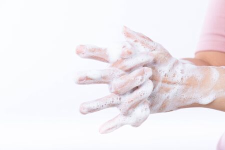 Closeup woman washing hands with soap on white background. Healthcare and disinfection concept.の写真素材