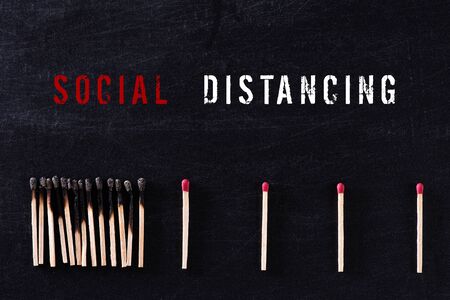 Social Distancing concept. Matchsticks burn, one piece prevents the fire from spreading by far from other by using social distancing concept to stop the coronavirus from spreading.の写真素材