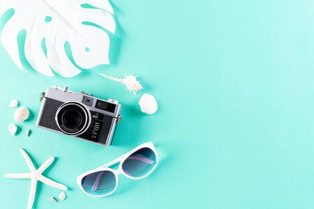 Retro film camera, sunglasses, starfish and sea shell on green pastel background for summer holiday and vacation concept.の写真素材
