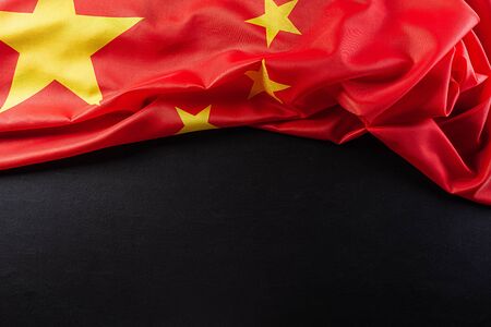 Top view flag of the Peoples Republic of China with copy space on black background.