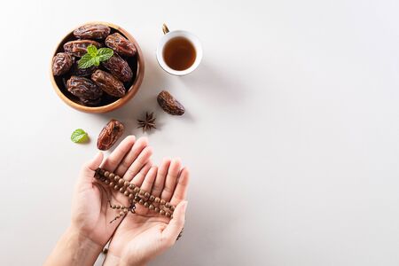 Table top view image of decoration Ramadan Kareem background,  dates fruit, coffee and hand with rosary beads. Flat lay background with copy space.の写真素材