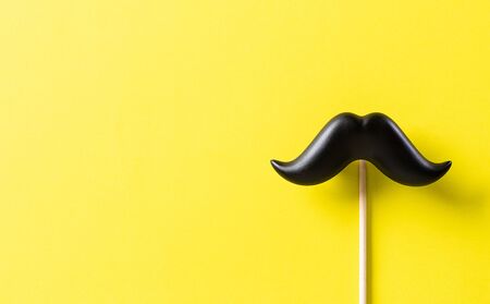 Father's day concept. Black moustache on yellow paper background.の写真素材