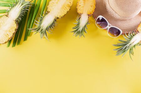 Colorful summer and holiday concept, Straw hat, sunglasses, palm branches and pineapple on yellow...