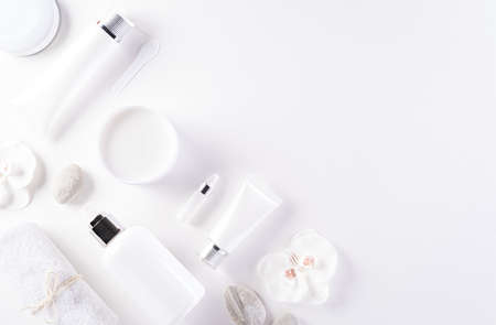 Cosmetic bottle containers, skin cream with flowers. Natural beauty and spa concept, Top view on white table background.の写真素材