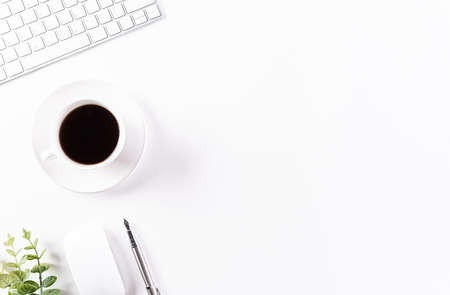 Flat lay, top view office table desk. Workspace with keyboard, office supplies, pencil, green leaf, and coffee cup with copy space on white background.の写真素材