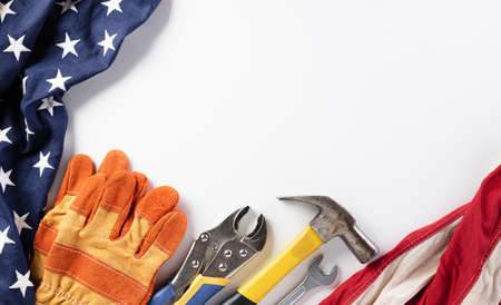 Happy Labor day concept. American flag with different construction tools on white background, with...