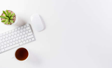 Flat lay, top view office table desk. Workspace with keyboard, mouse, green leaf, and coffee cup...