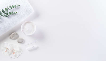 Cosmetic bottle containers, skin cream with flowers. Natural beauty and spa concept, Top view on white table background.の写真素材