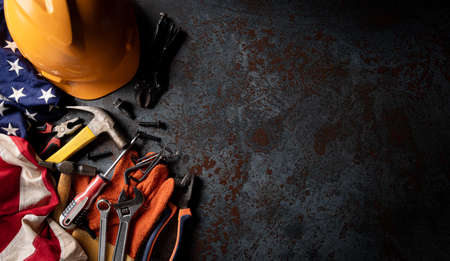 Happy Labor day concept. American flag with different construction tools on dark stone background, with copy space for text.の写真素材